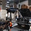 Werkstatt mit Hebebühne auf der gerade zwei Ford Mustangs repariert werden